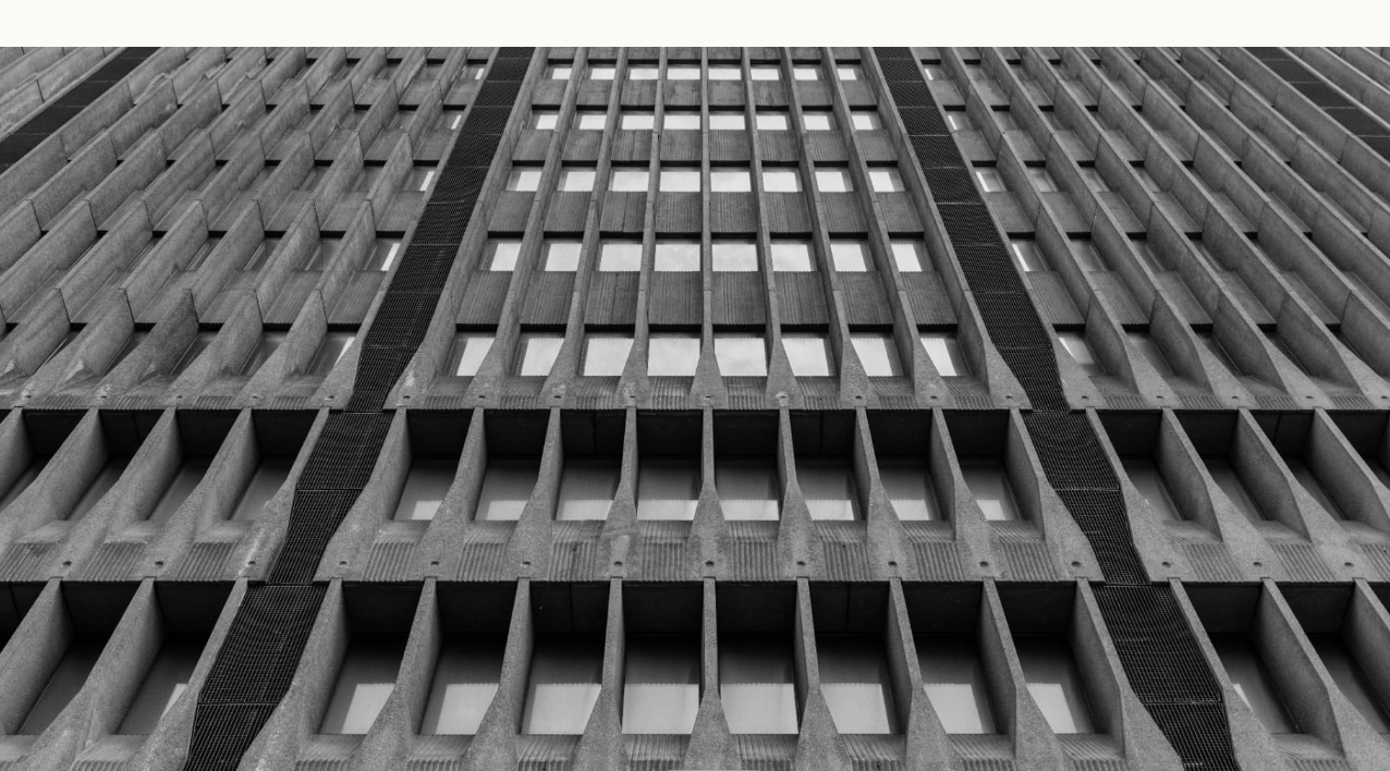 Fachada de concreto en blanco y negro con patrón geométrico de ventanas